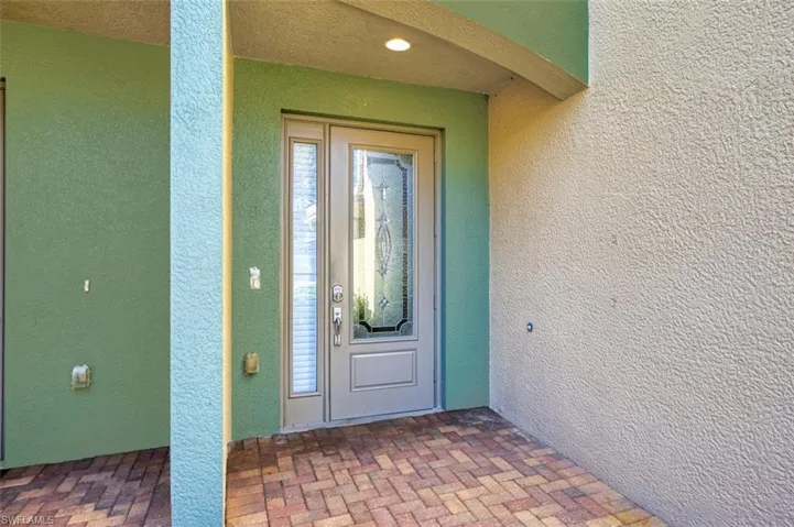Doorway to property featuring stucco siding