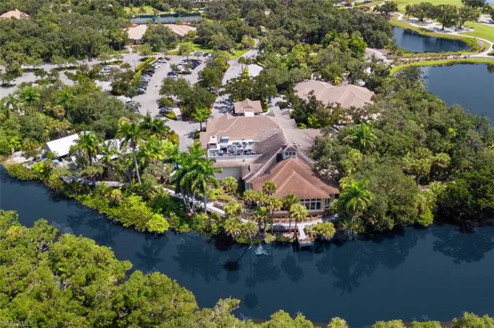 Aerial view of property's location with a large body of water and a tree filled landscape