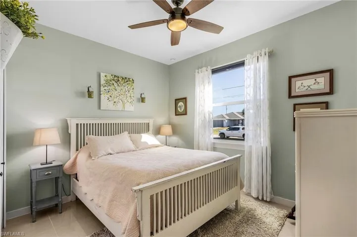 Bedroom with light tile patterned flooring and ceiling fan