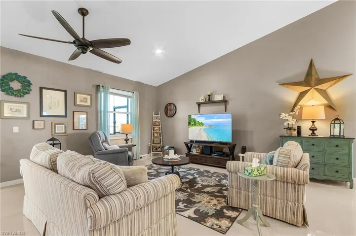 Living room featuring ceiling fan and vaulted ceiling