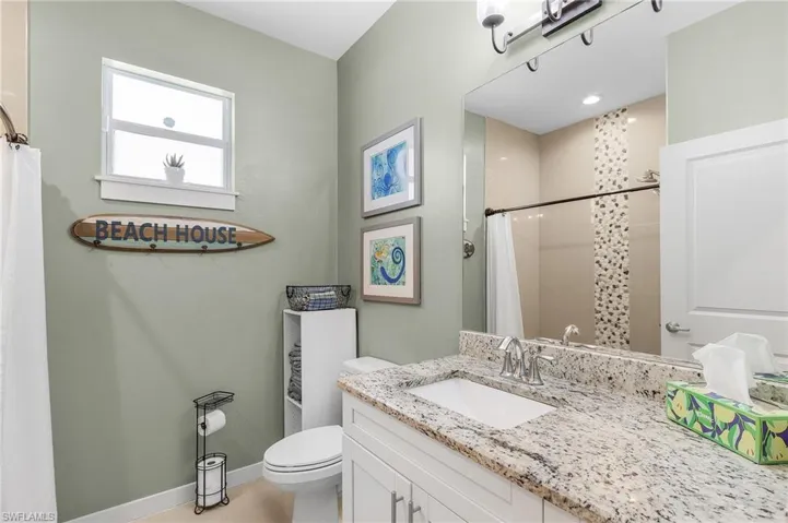 Bathroom with vanity, a shower with curtain, and toilet
