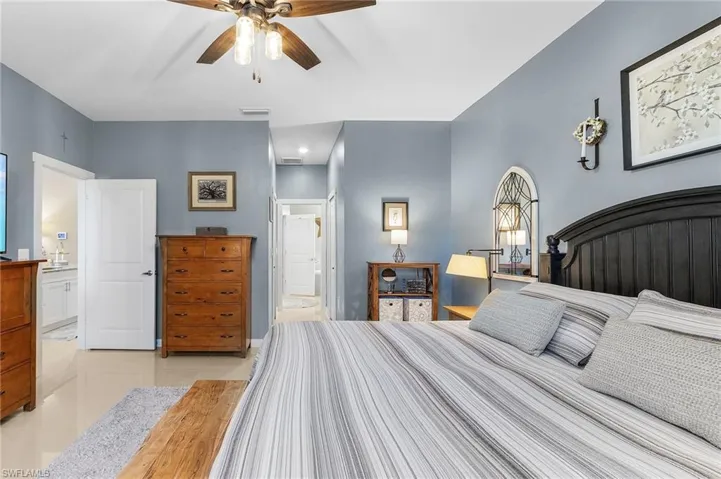 Bedroom featuring light tile patterned floors and ensuite bath