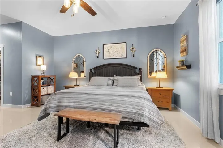 Tiled bedroom featuring ceiling fan