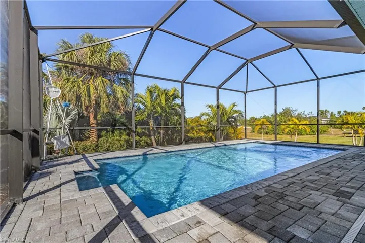 View of pool with a patio and glass enclosure