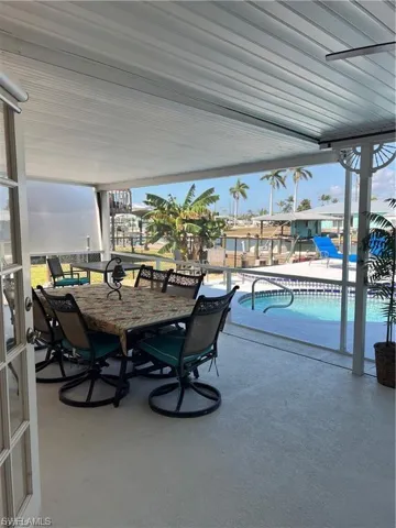 Screened-in patio featuring a concrete floor, white slatted ceiling, and an outdoor swimming pool with surrounding deck