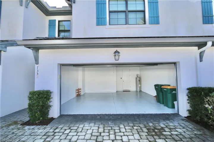 Garage with decorative driveway and water heater