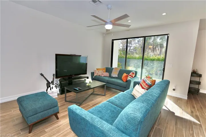 Living area with wood tiled floors, ceiling fan, and recessed lighting