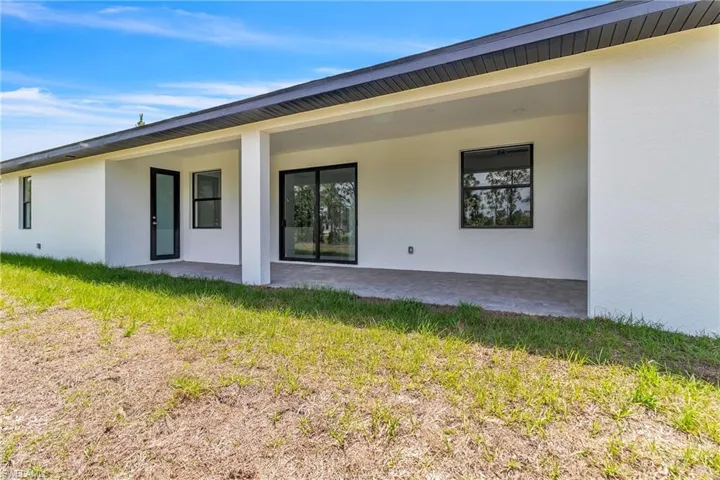 Back of house with a patio and stucco siding