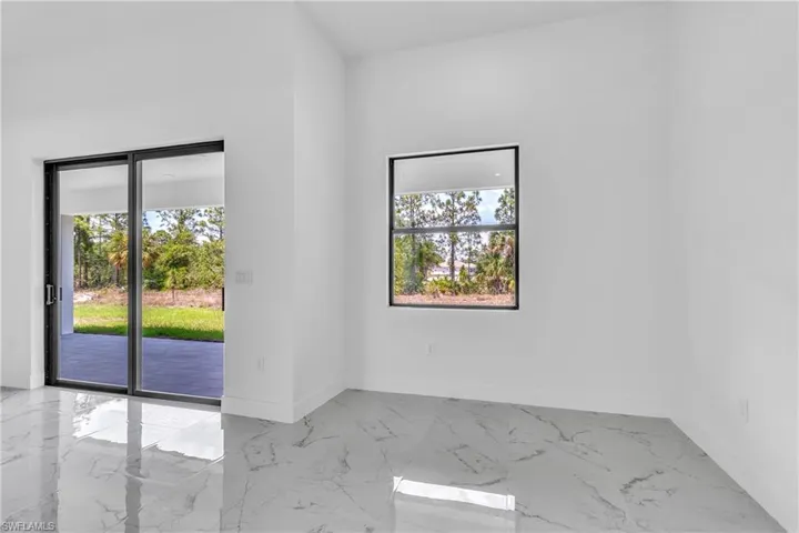 Empty room featuring light marble finish flooring and baseboards