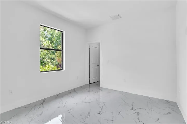 Unfurnished room with light marble finish floors and baseboards