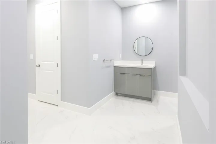 Bathroom with vanity and light marble finish flooring