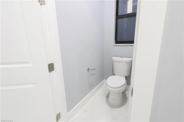 Bathroom featuring baseboards and marble finish floors