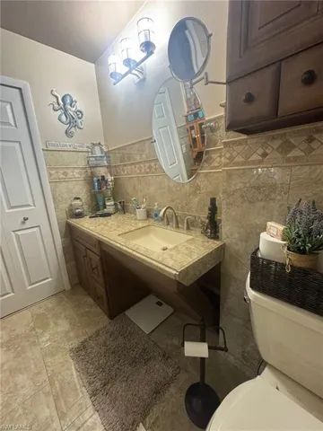 Half bath featuring vanity and wainscoting