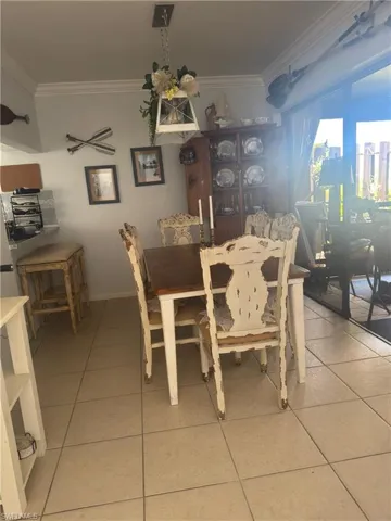 Dining room featuring crown molding and light tile patterned floors