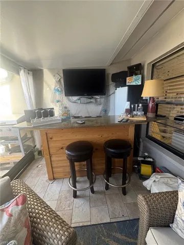 Bar featuring dark countertops and freestanding refrigerator