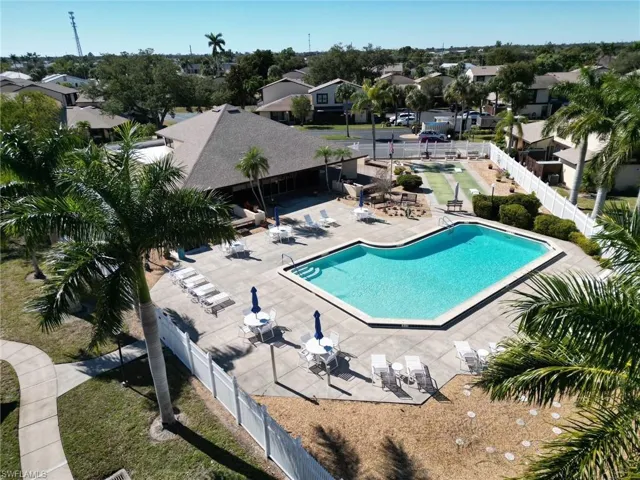 Community pool with a patio area and a residential view
