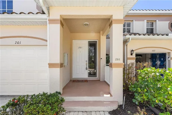 Doorway to property featuring stucco siding, covered porch, and a tiled roof