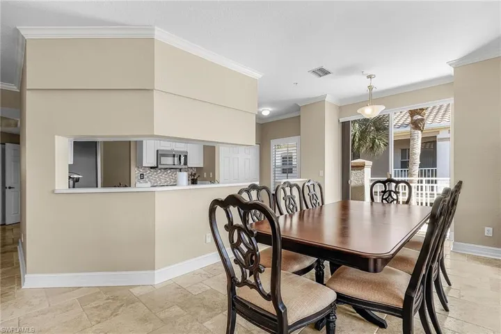 Dining room featuring crown molding and stone tile floors