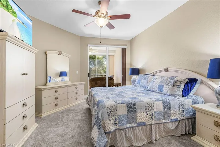 Bedroom featuring carpet flooring, a textured wall, a ceiling fan, and access to exterior