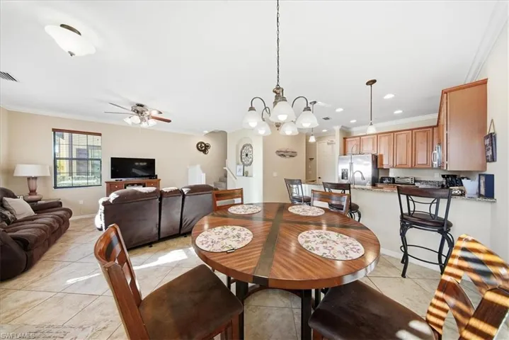 Dining space featuring ornamental molding, a chandelier, ceiling fan, recessed lighting, and light tile patterned floors