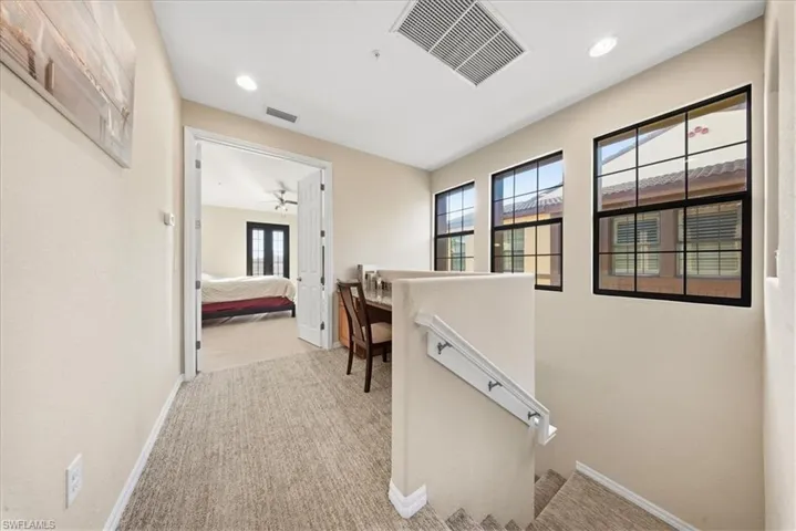 Corridor with light carpet and recessed lighting