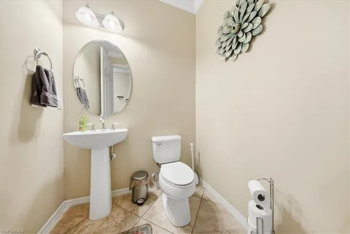 Bathroom with tile patterned flooring and ornamental molding
