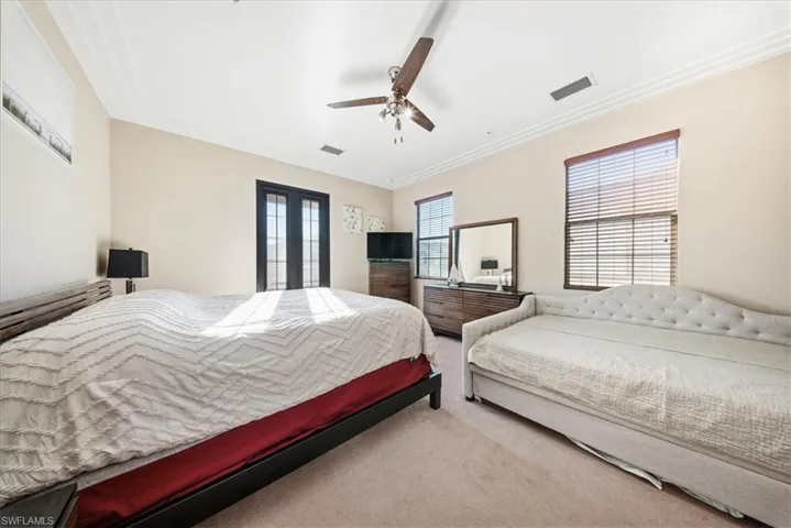 Bedroom featuring carpet floors, a ceiling fan, and crown molding