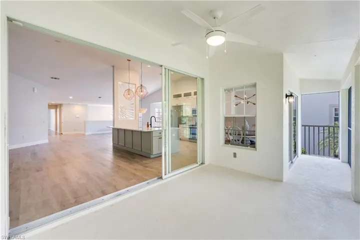 Outdoor covered balcony with stacking slider doors and peaceful preserve views.