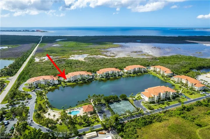 Drone / aerial view of a nearby body of water and apartment complex