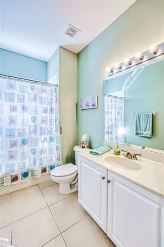 Bathroom with vanity, a shower with curtain, and light tile patterned flooring
