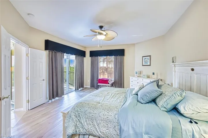 Bedroom with access to exterior, light wood-style floors, and a ceiling fan