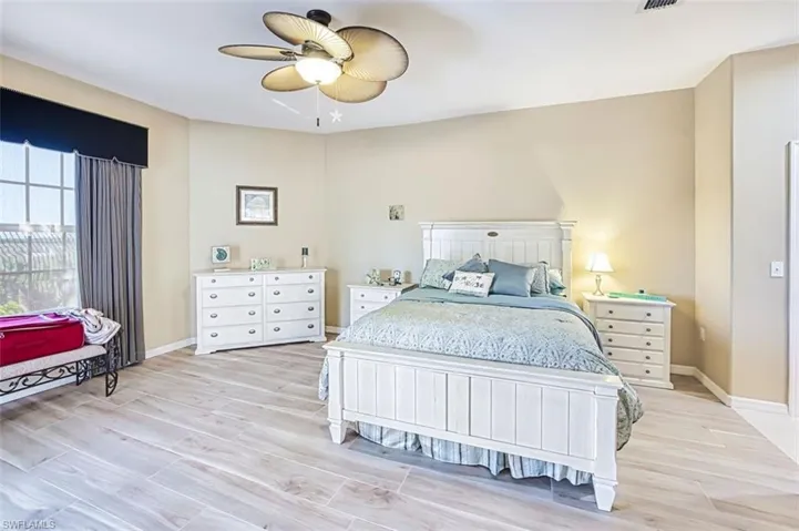 Bedroom with wood tiled floors and a ceiling fan