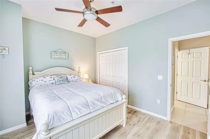 Bedroom with ceiling fan, light wood-type flooring, and a closet