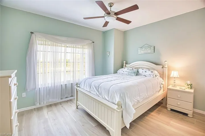 Bedroom with light wood finished floors and a ceiling fan