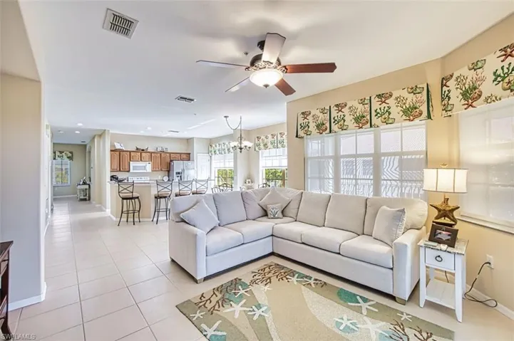 Living room featuring a chandelier, a ceiling fan, and light tile patterned floors