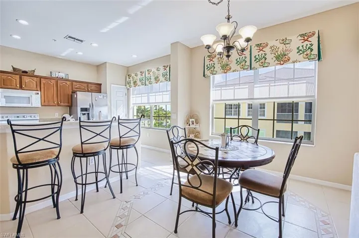 Dining space featuring inlaid floor details, light tile patterned floors, and a chandelier