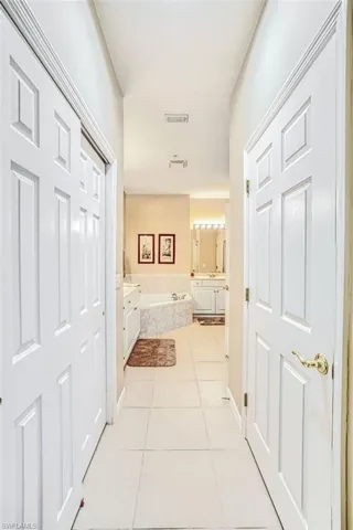 Hallway with light tile patterned flooring and baseboards
