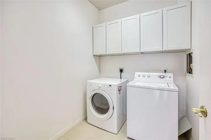 Laundry area with cabinet space and washing machine and clothes dryer