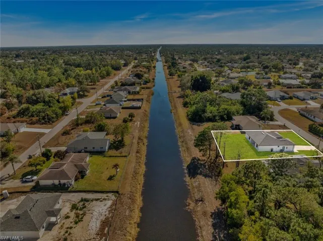 Aerial view of residential area featuring a nearby body of water