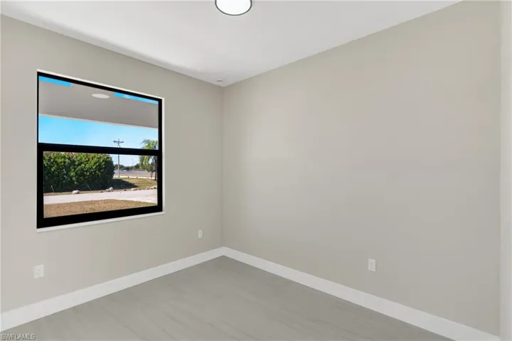 Spare room with baseboards and light wood-style floors
