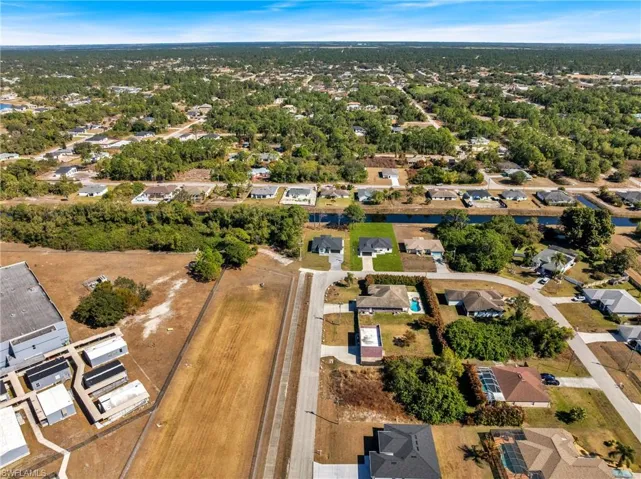 Aerial view of property and surrounding area featuring nearby suburban area