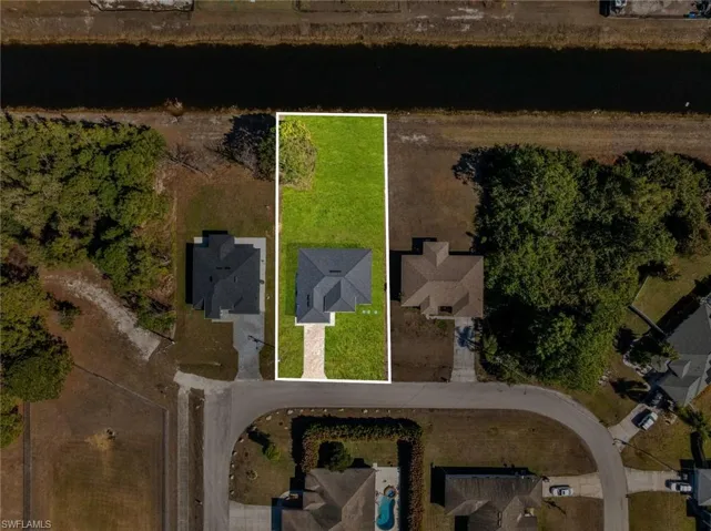 Aerial view of property's location with a large body of water and property boundaries highlighted
