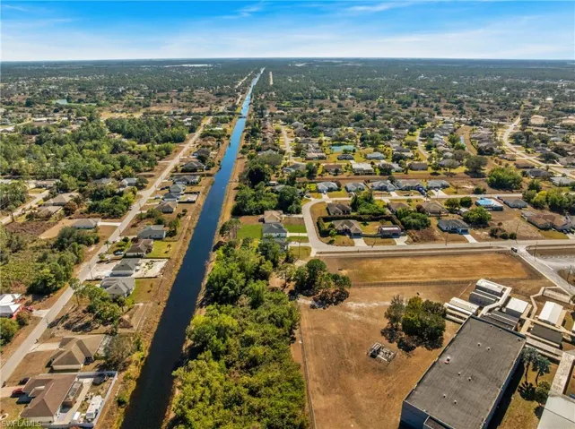 Aerial view of property's location with nearby suburban area and a nearby body of water