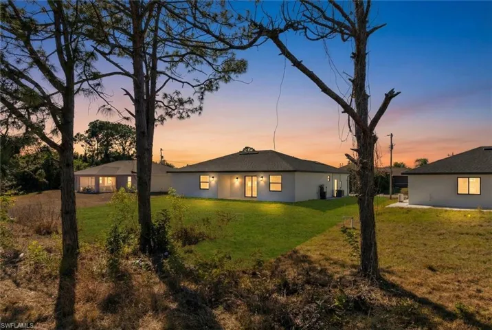 Back of house featuring a yard, stucco siding, and a patio