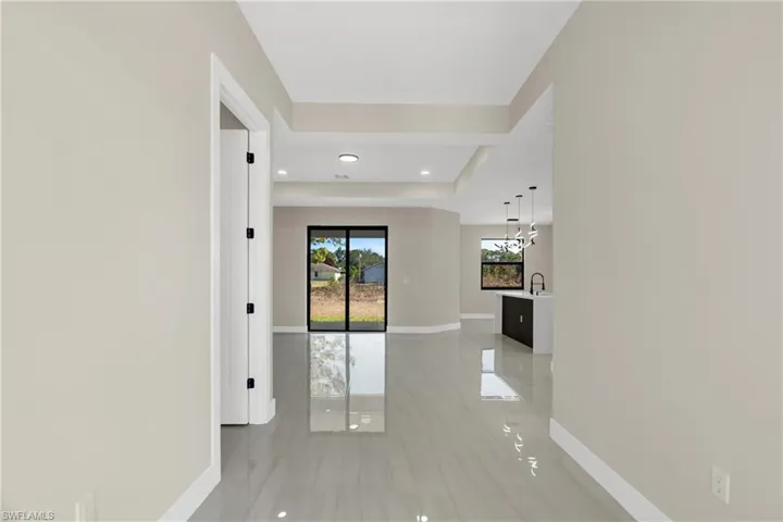Corridor featuring recessed lighting and a raised ceiling