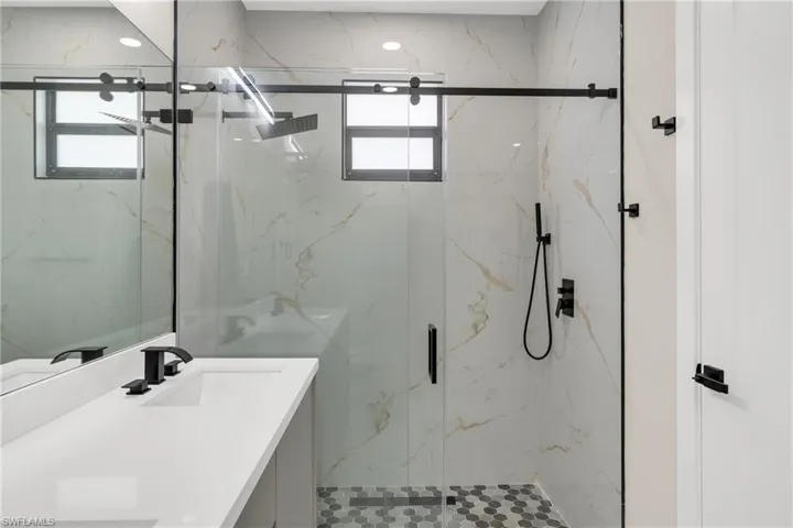 Full bath with vanity and a marble finish shower