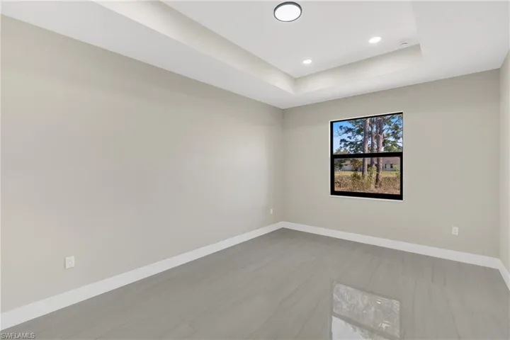 Unfurnished room with a tray ceiling and recessed lighting