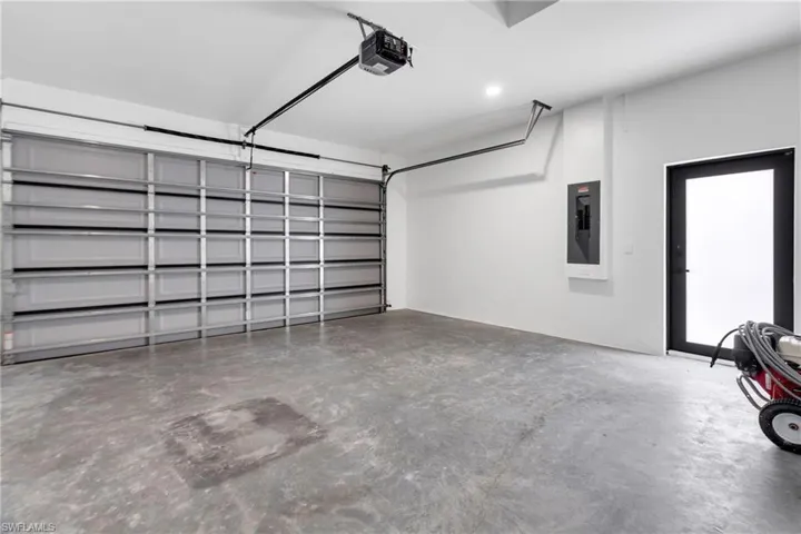 Garage featuring electric panel and a garage door opener