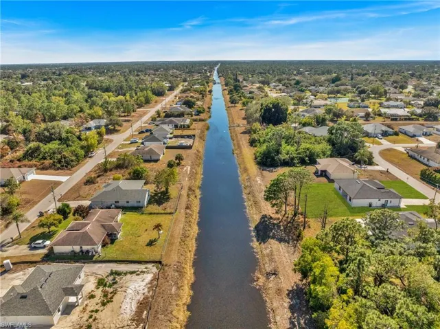 Aerial view of property and surrounding area with nearby suburban area and a nearby body of water