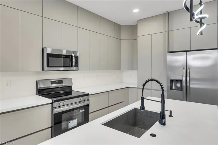 Kitchen with stainless steel appliances, modern cabinets, gray cabinetry, and recessed lighting